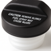 A close-up of a black Toyota 77310-12140 Fuel Cap with white warning text reading 'CAUTION REMOVE SLOWLY FUEL SPRAY MAY CAUSE INJURY' on a white background.