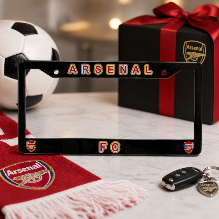Arsenal FC license plate frame with soccer ball, gift box, and scarf on a table.