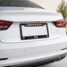 Car license plate frame with 'Arsenal FC' branding on a white car.