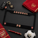 Arsenal FC merchandise including a license plate frame, keychain, towel, pen, and soccer ball on a dark surface.