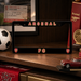 Arsenal FC license plate frame on a wooden surface with sports memorabilia.