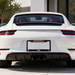 White car with a visible 'Arsenal' license plate holder on a blurred background