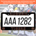 A custom Auburn Tigers license plate with a black frame, featuring the word 'AUBURN' at the top, placeholder license plate numbers 'AAA 1282' in the center, and 'TIGERS' with Auburn logos at the bottom. The background is a blurred photo of a football team in uniform.