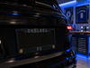 Black car with 'CHELSEA FC' license plate in a garage setting