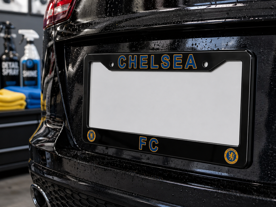 Black car with a license plate frame displaying 'CHELSEA FC' on a blurred background.
