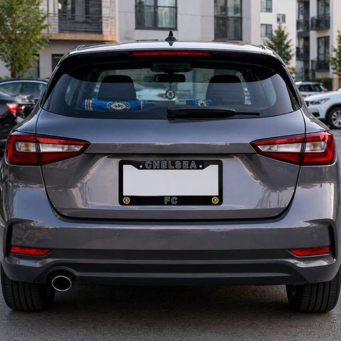 Back view of a gray car with 'Chelsea' license plate in an urban setting