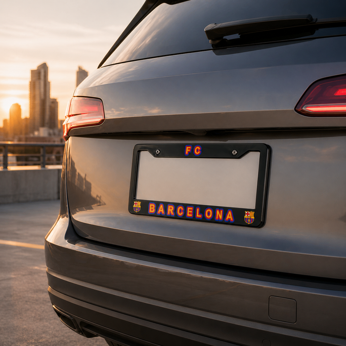 Car with a license plate frame displaying 'FC BARCELONA' against a cityscape background.