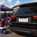 Black car with FC Barcelona license plate at a sports event, featuring fans and branded merchandise.
