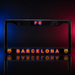 A black license plate frame featuring 'FC BARCELONA' in orange and blue lettering, with FC Barcelona club crests on the lower corners, shown against a dark studio background with red and blue lighting.