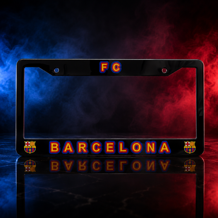 A black license plate frame featuring 'FC BARCELONA' in glowing orange and blue lettering, with FC Barcelona club crests on both sides, set against a dramatic blue and red smoky background with a reflective dark surface below.