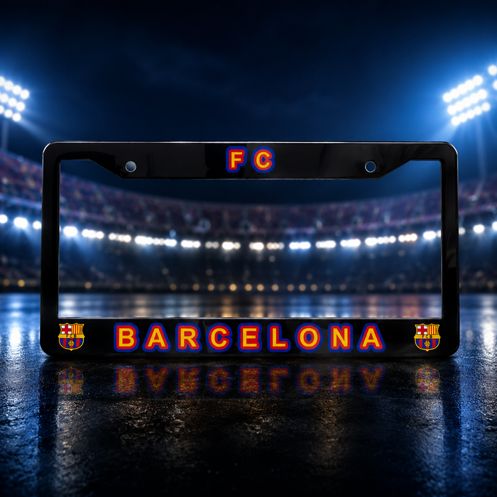 A black license plate frame featuring 'FC BARCELONA' in glowing orange and blue lettering, with FC Barcelona crests on the bottom corners, set against a blurred stadium background.
