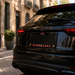 Close-up rear view of a glossy black SUV parked on a cobblestone street, showing a custom license plate with red and blue LED-style lettering that reads FC and BARCELONA.