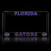 A black license plate frame featuring 'FLORIDA' at the top and 'GATORS' at the bottom in blue outlined lettering, with Florida Gators logo graphics on the lower corners, shown on a reflective black background.