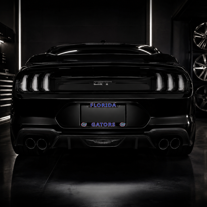 Rear view of a black Ford Mustang GT with custom blue 'FLORIDA GATORS' license plate in a dark garage setting.