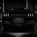 Rear view of a black Ford Mustang GT with custom blue 'FLORIDA GATORS' license plate in a dark garage setting.