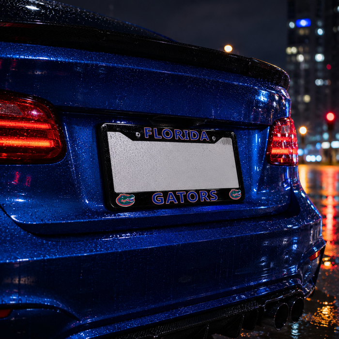 A close-up rear view of a blue car on a wet city street at night, featuring a Florida Gators themed license plate frame with 'FLORIDA' at the top and 'GATORS' at the bottom, flanked by small gator logos.