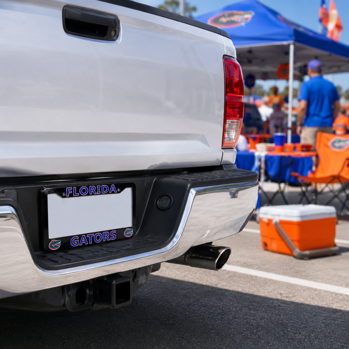 A close-up rear view of a white pickup truck at a sunny outdoor event, featuring a custom Florida Gators license plate frame with the words 'FLORIDA GATORS' in blue and orange lettering.
