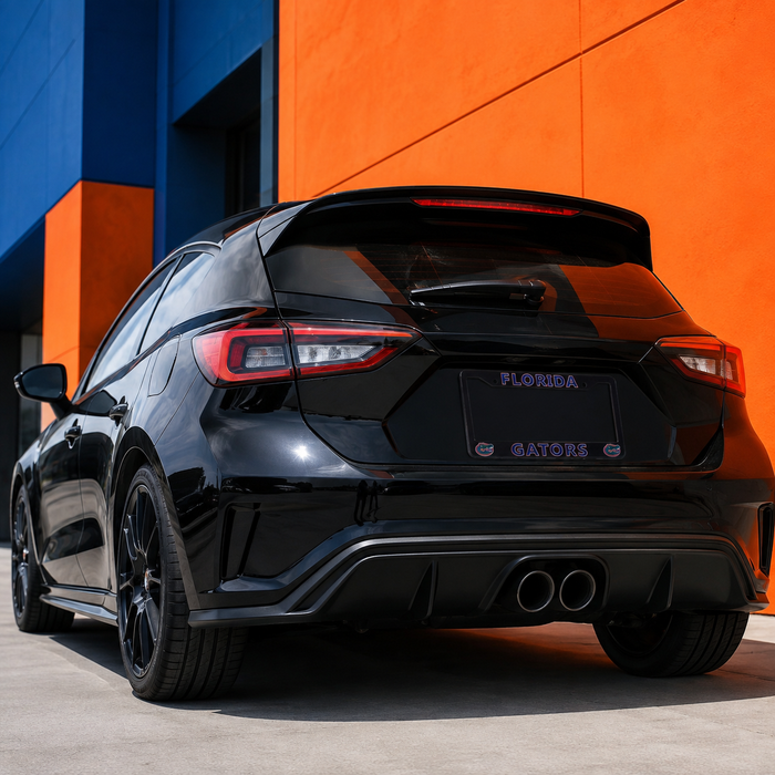 A black hatchback car photographed from the rear in an outdoor urban setting, parked against a bold orange and blue building wall. The rear of the car shows a spoiler, dual exhaust, LED taillights, and a Florida license plate with Gators branding.
