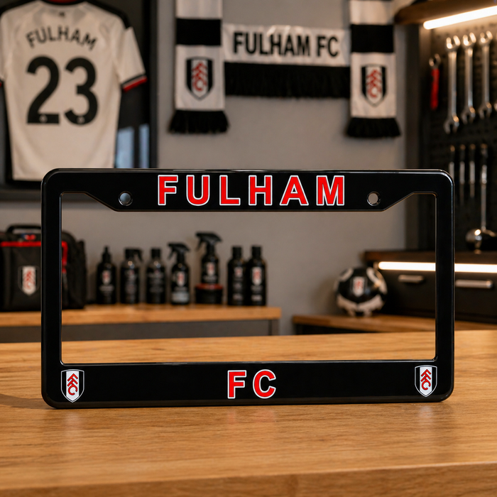 Fulham FC license plate frame on a wooden surface with sports merchandise in the background