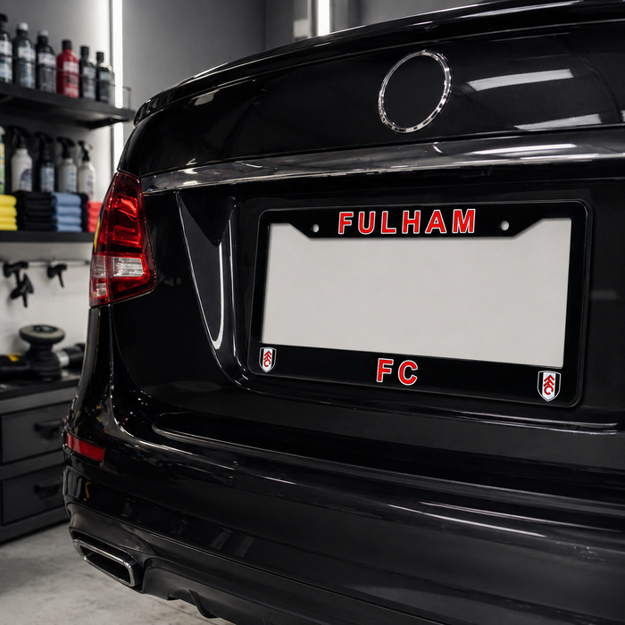 Black car with 'Fulham FC' license plate in a garage setting