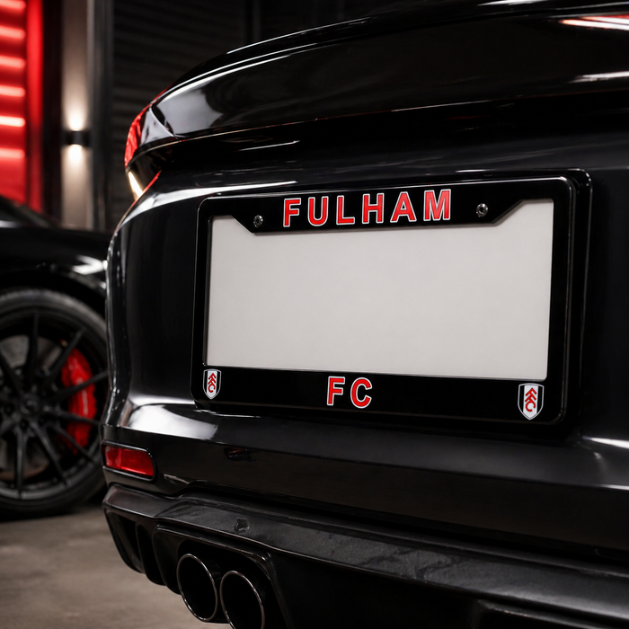 Black car with 'Fulham FC' license plate frame in a dark setting