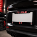 Black car with 'Fulham FC' license plate frame in a dark setting