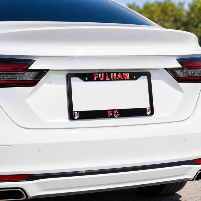 White car with a 'Fulham FC' license plate frame on a blurred outdoor background