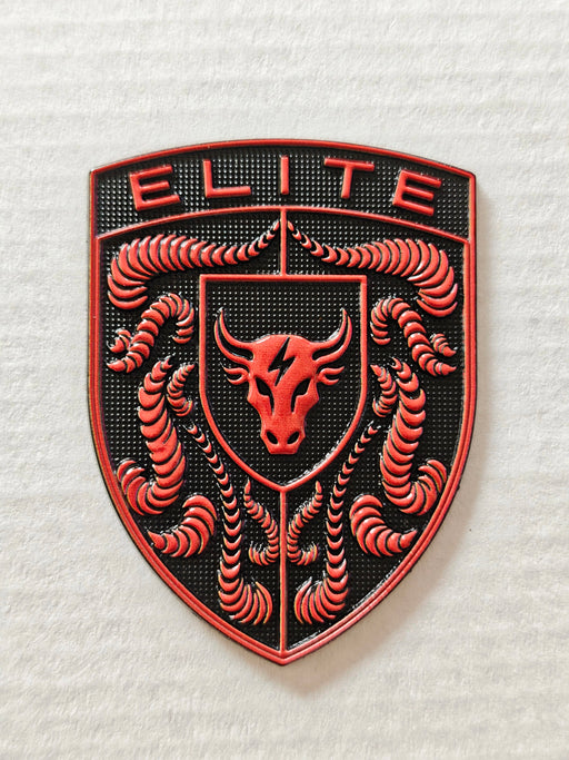A red porsche emblem featuring a red bull head in the center, crumrine designs on both sides, and the word 'ELITE' at the top, shown on a textured off-white background.