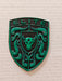 A green and black porsche emblem featuring the word 'ELITE' at the top, a bull head in the center, and crumrine designs around the border, photographed on a light textured background.