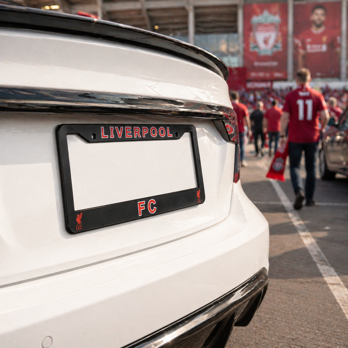 White car with Liverpool FC license plate frame at a sports event.
