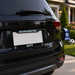 Black SUV with 'Manchester City' license plate frame in front of a house.