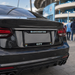 Black car with 'Manchester City' license plate in front of a stadium.