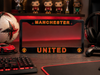 Manchester United-themed desk setup with a monitor cover, keyboard, and sports ball.