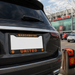Black car with Manchester United license plate in front of a stadium.