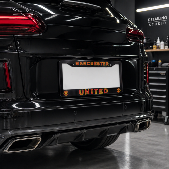 Black car with Manchester United license plate in a detailing studio