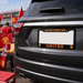 Black car with Manchester United license plate frame at a sports event.