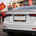 White car with Manchester United license plate in front of a stadium.