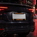 Black car with Manchester United license plate in an urban setting at night.