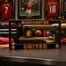 Manchester United car license plate frame with sports memorabilia in the background