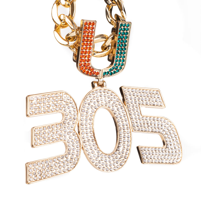 A gold-tone chain necklace featuring a large '305' pendant and a 'U' charm, both heavily embellished with clear rhinestones. The 'U' charm has one half in orange and the other in teal, while the '305' pendant is entirely clear rhinestone-covered.