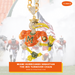 A gold-tone chain necklace with a highly detailed Miami Hurricanes football player charm, heavily embellished with orange, yellow, green, and white rhinestones. The background is a faded, smoky sports stadium scene with football players, and text overlays identify the item as a Sebastian 'The Ibis' Turnover Chain by Elite Auto.