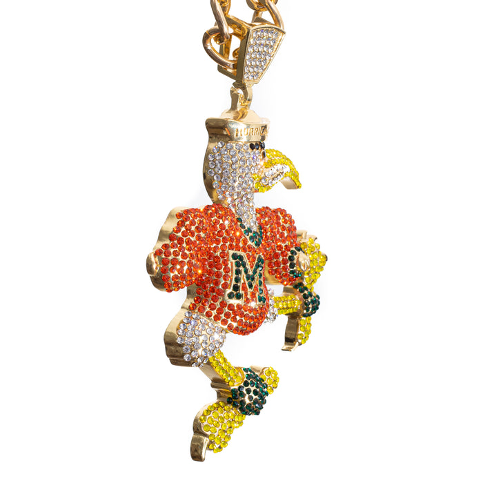 A gold-tone eagle pendant charm embellished with rhinestones in orange, green, yellow, and white, featuring the letter 'M' on its chest and a gold-tone chain attached at the top, shown against a plain white background.