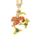 A gold-plated bird mascot pendant, likely representing Miami, covered in rhinestones. The bird is wearing an orange jersey with a green 'M' on the chest, yellow beak and legs, and green and gold accents on its feet, set against a plain white background.