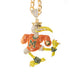 A gold-plated chain necklace with a highly detailed, rhinestone-encrusted mascot pendant. The mascot is primarily orange and yellow with green accents, wearing a gold crown and a jersey with a large letter 'M'.