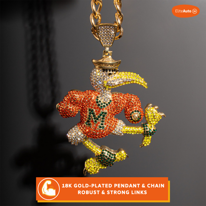 A gold-plated pendant necklace featuring a stylized bird mascot wearing an orange jersey with a large 'M' and yellow accents, covered in rhinestones, hanging from a matching chain. The image has promotional text overlays and a brand logo in the top right corner.