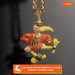 A gold-plated pendant necklace featuring a stylized bird mascot wearing an orange jersey with a large 'M' and yellow accents, covered in rhinestones, hanging from a matching chain. The image has promotional text overlays and a brand logo in the top right corner.