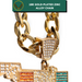 Close-up of a gold-toned chain necklace with a shield-shaped link paved with clear rhinestones, shown against a white background with a green text banner reading '18K GOLD-PLATED ZINC ALLOY CHAIN'. Part of a colorful rectangular pendant is visible at the bottom.