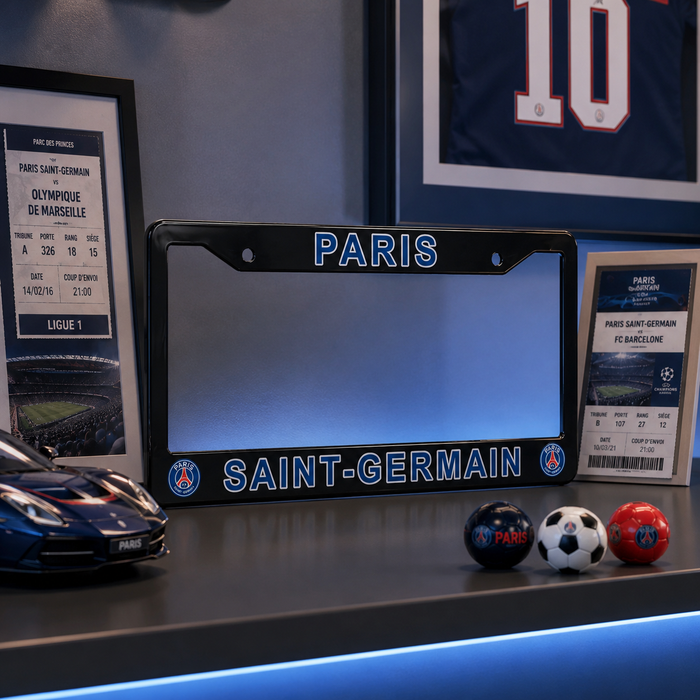 A Paris Saint-Germain license plate frame displayed on a shelf, surrounded by framed match tickets, a Paris jersey, a model car, and small soccer balls. The license plate frame has 'PARIS' at the top and 'SAINT-GERMAIN' at the bottom with PSG logos on the corners.