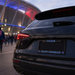 Black car with 'Paris Saint-Germain' license plate in front of a stadium.