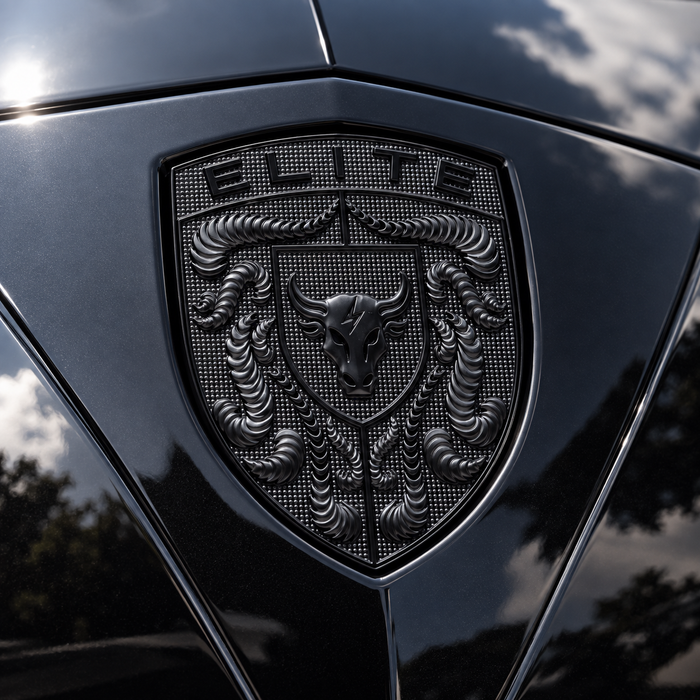 A close-up of a black porsche shield emblem on a glossy black vehicle body, featuring a bull head and the word "ELITE" at the top.